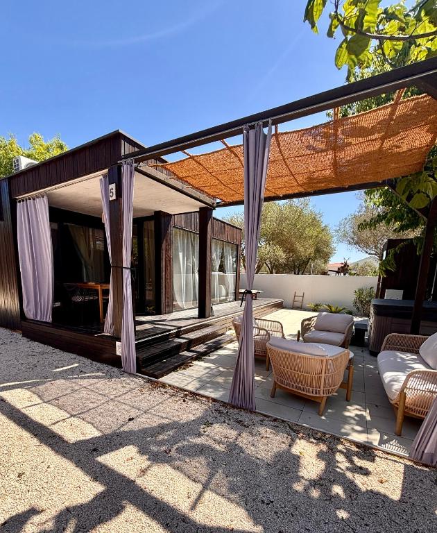 a screened in patio with a couch and chairs at Stylish beach house in Privlaka in Privlaka