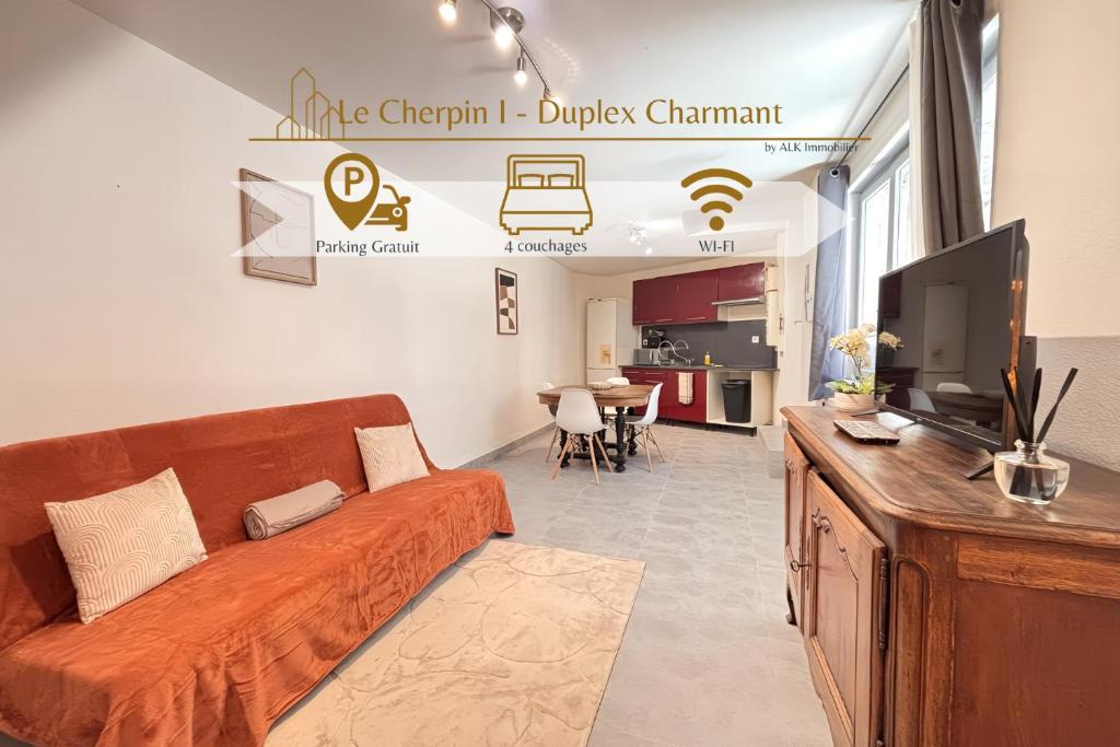 a living room with a couch and a tv at Le Cherpin I Duplex charmant in Roanne