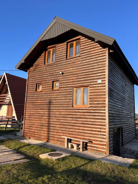 a large wooden house with a gambrel roof at brown bear lodge in Žabljak
