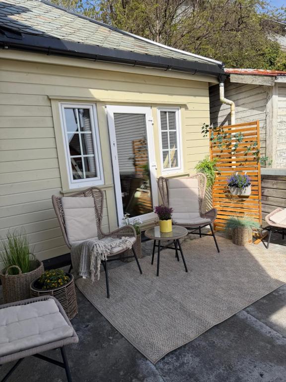 a patio with two chairs and a table and a house at Leilighet i Sokndal in Sokndal