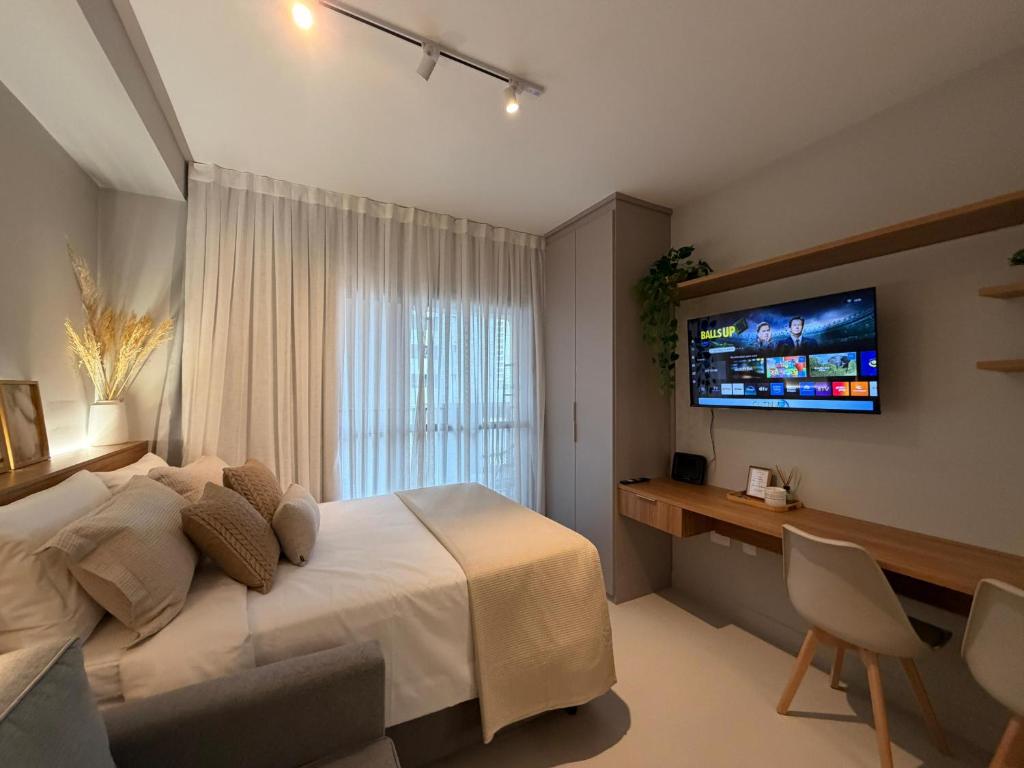 a bedroom with a bed and a television on the wall at 07 La Limeña Estúdio completo perto do consulado in São Paulo