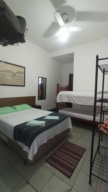a bedroom with two beds in a room at Pousada Regis Bocaina SJB in São José do Barreiro