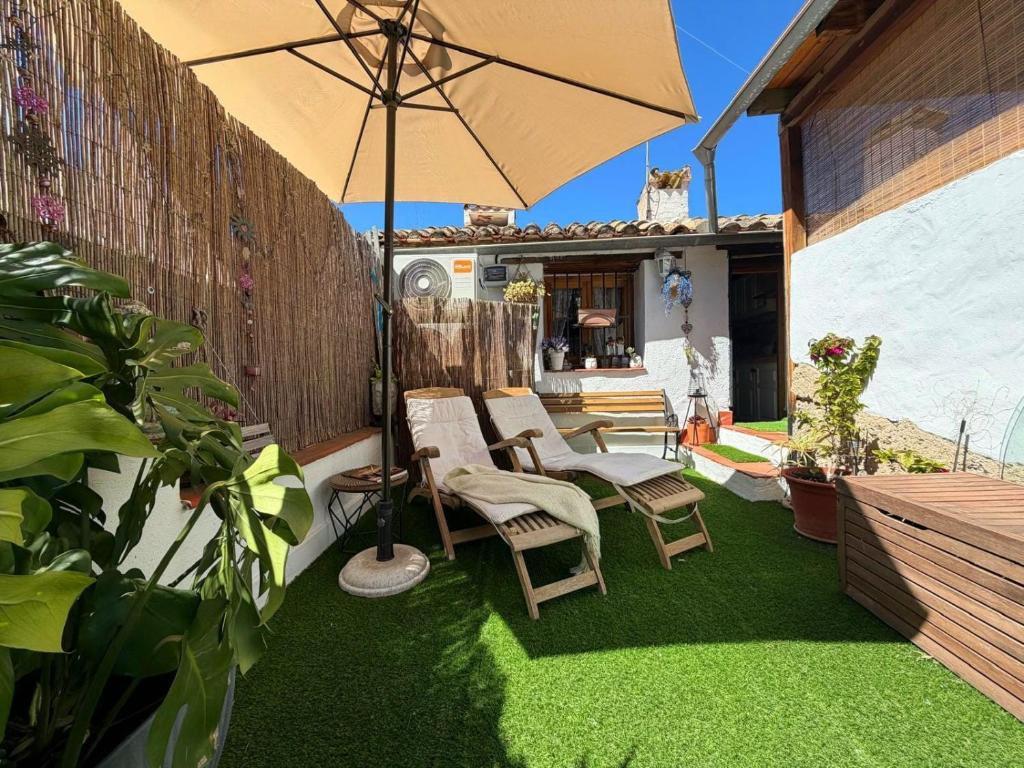 a patio with a table and chairs and an umbrella at Casa Trinidad in Denia