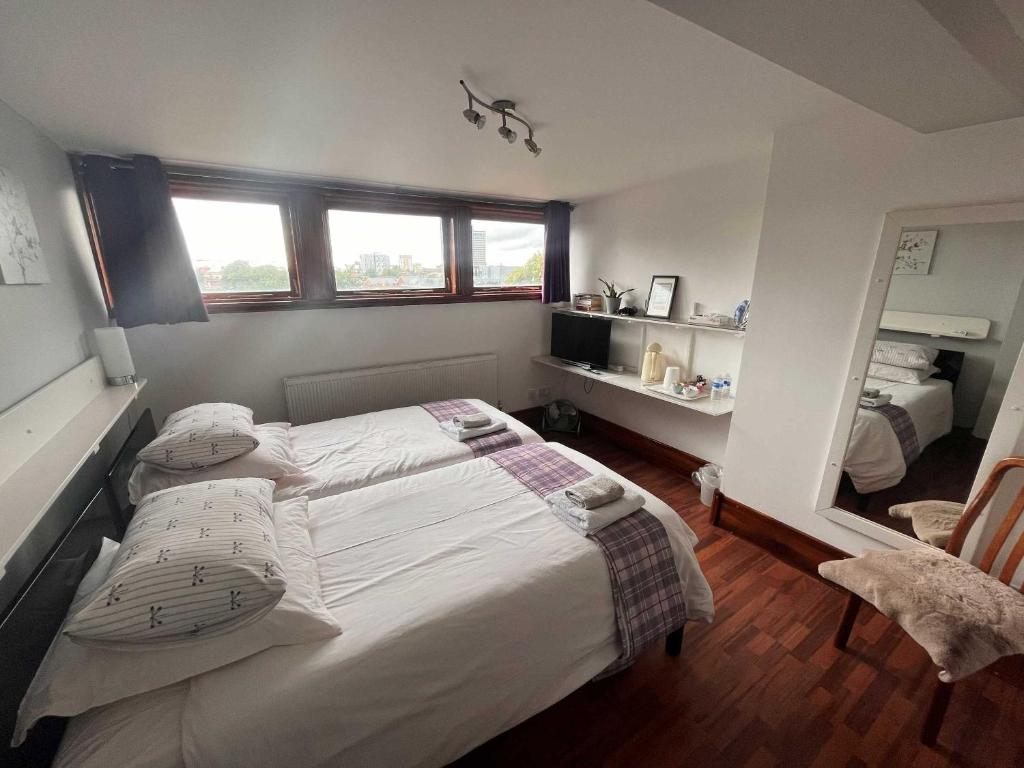 a small bedroom with a bed and a mirror at Breeze Guest House in Bootle