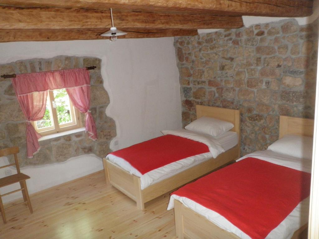 two beds in a room with a stone wall at Holiday Home Rizvan City in Brušane