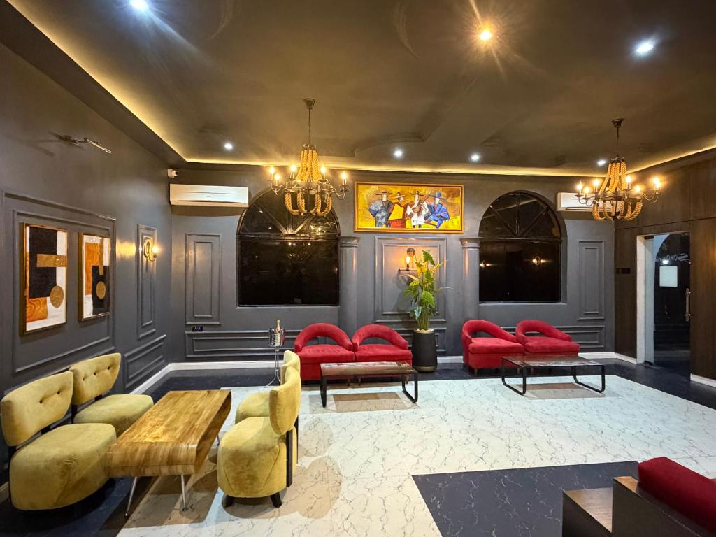 a living room with red furniture and red chairs at de brit hotel in Benin City