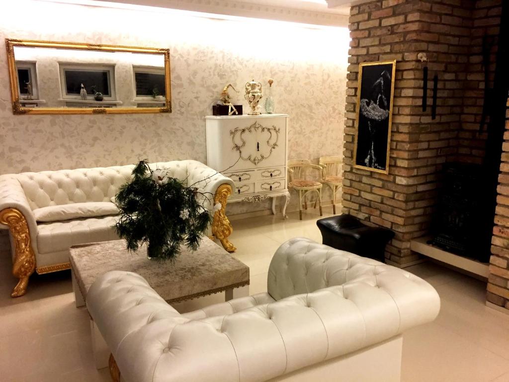 a living room with two white couches and a fireplace at Vilnius Luxury Apartment 3 in Vilnius