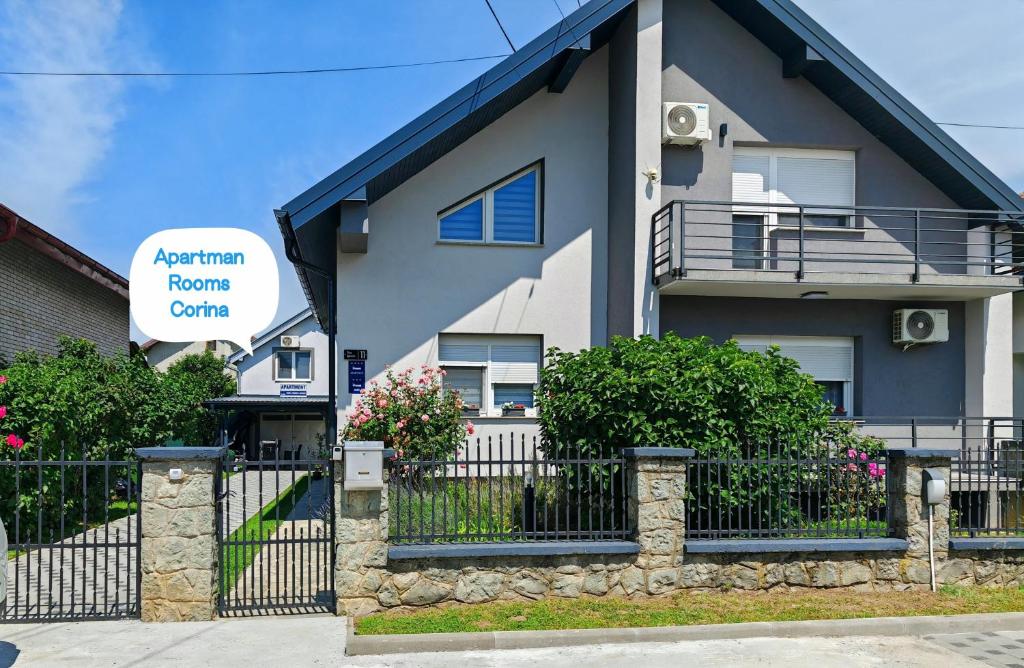 a house with a fence in front of it at Apartman - sobe Corina-blizu Osijeka in Bilje