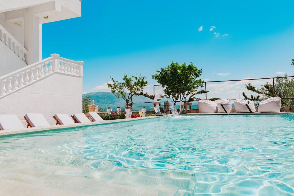 a swimming pool at a resort with lounge chairs at Villa JOSANA in Sarandë