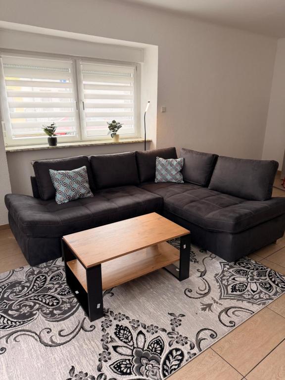 a living room with a black couch and a coffee table at Appartement Heidstock in Völklingen