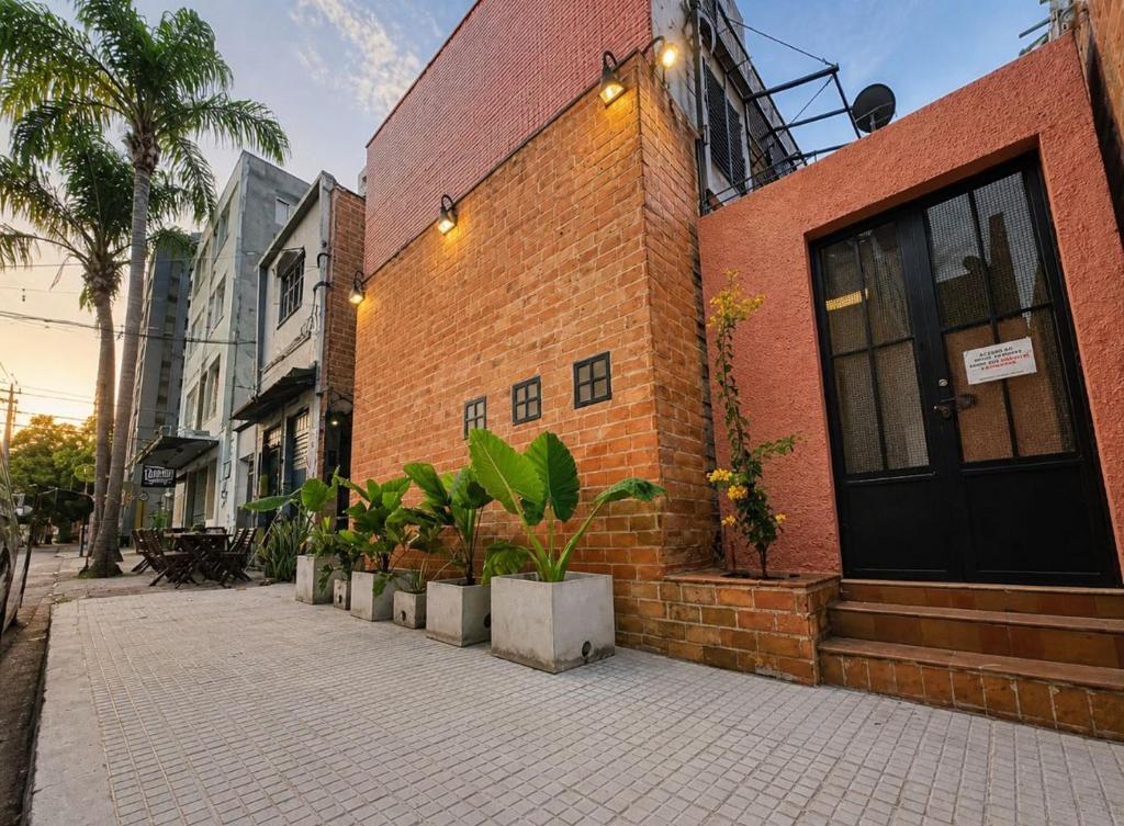 a brick building with potted plants in front of it at Unidade 2 - GoHost Suítes in Ribeirão Preto