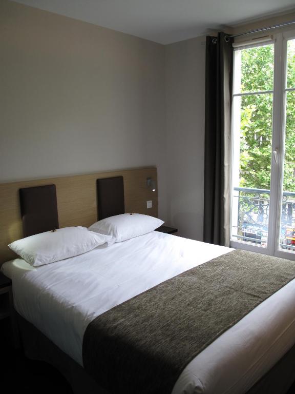 Voodi või voodid majutusasutuse Source Hôtel toas