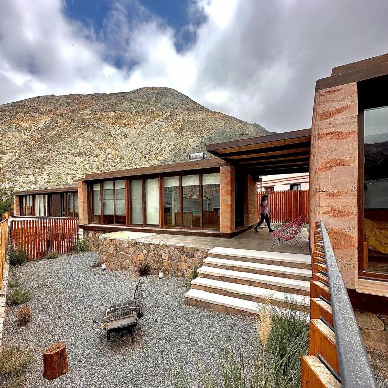 a house with a mountain in the background at Tierra Viva in Purmamarca