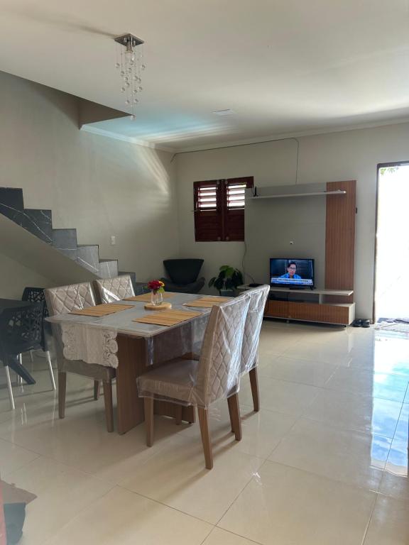 a living room with a wooden table and chairs at Maria Luiza da silva in Japaratinga