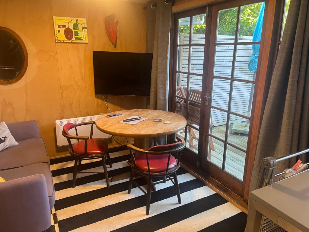a room with a table and chairs and a television at The Windsor Suite in New Plymouth
