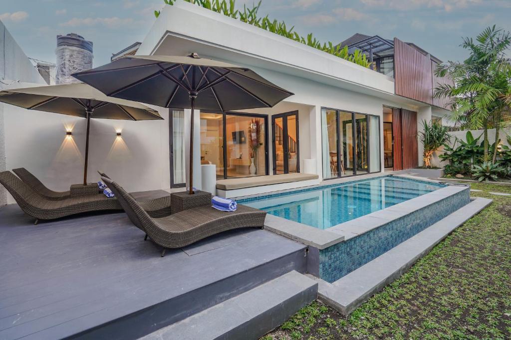 a villa with a swimming pool and a house at Sanara Oasis Villa in Canggu