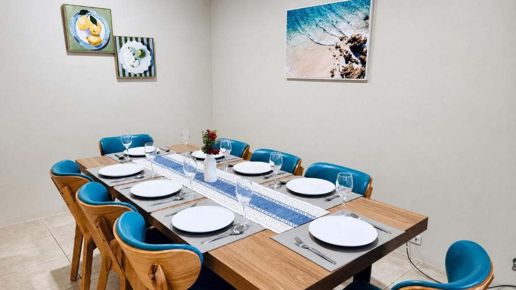 a dining room with a wooden table and blue chairs at Busselton Beach Villa - Family & Pet Friendly in Geographe