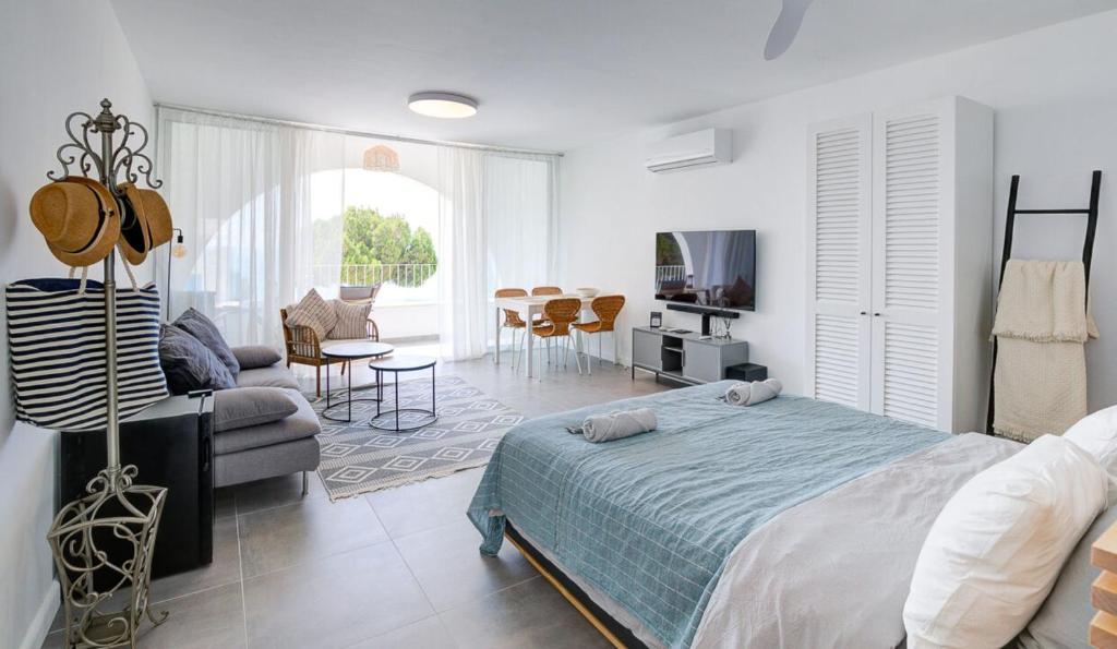 a bedroom with a bed and a living room at Beachfront Bliss in Pissouri