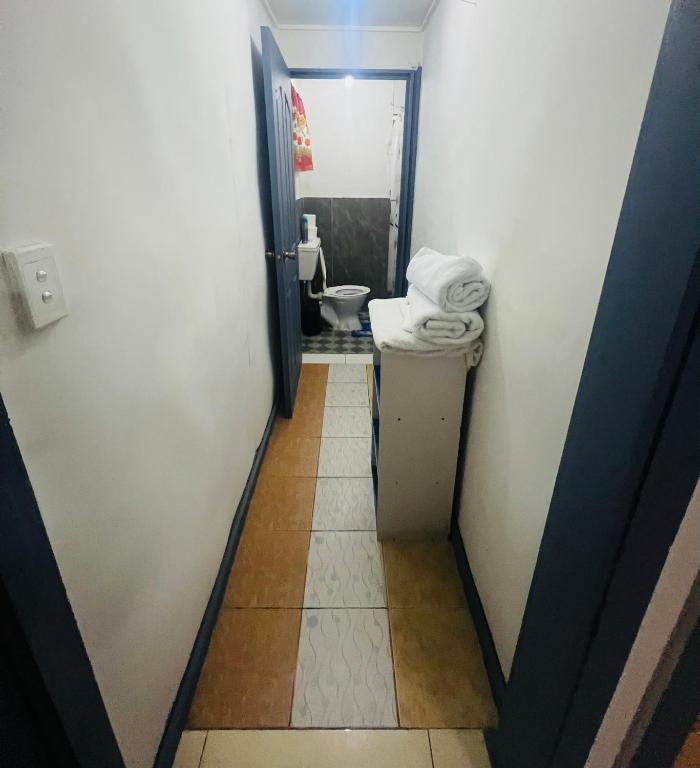 a hallway to a bathroom with a toilet in it at Manutapu Lodge in Tongatapu