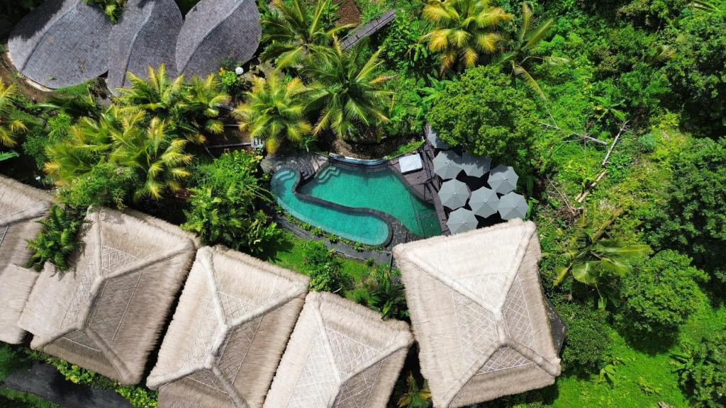 an overhead view of a swimming pool and palm trees at Sweet Escape - Boutique Hotel in Sidemen