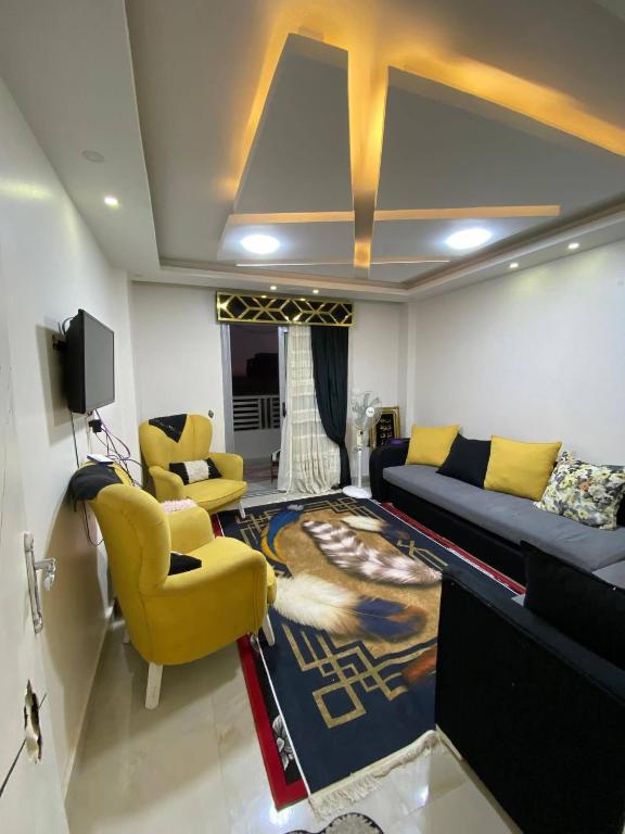 a living room with a couch and yellow chairs at Bianki Home in Alexandria