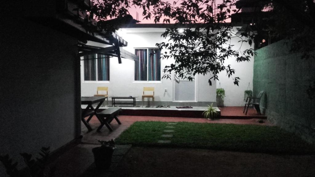 a room with a table and chairs in a house at night at Araliya White House in Negombo