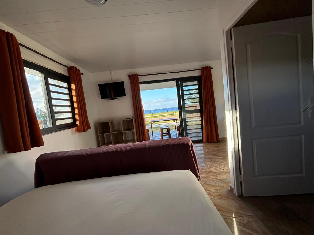 a room with a couch and a window with a view at Pautoora Lodge in Rurutu