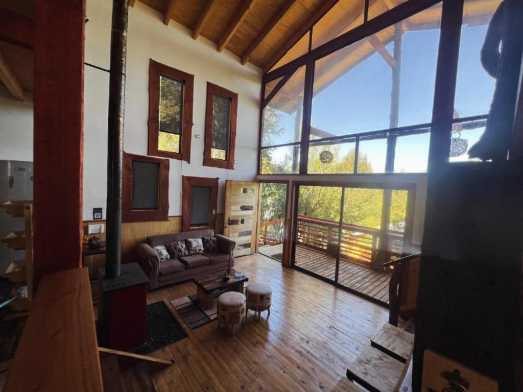 a living room with a couch and a large window at Colibrí lodge in Recinto
