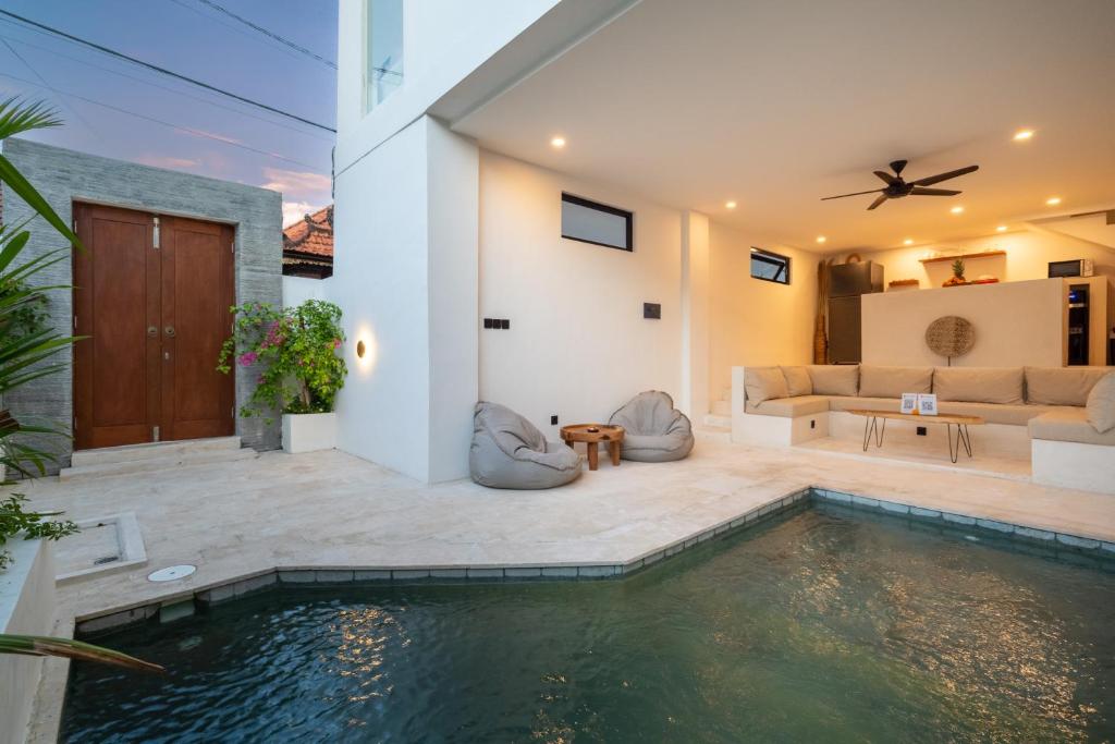 a house with a swimming pool and a living room at Villa Ombak - 1BR Private Luxury Villa 150m from Seseh Beach in Canggu
