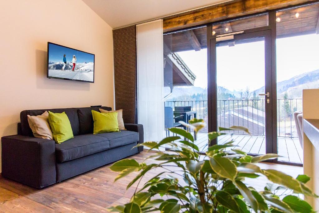 a living room with a couch and a large window at Apartment gmiatlich Wohnen in Hollersbach im Pinzgau