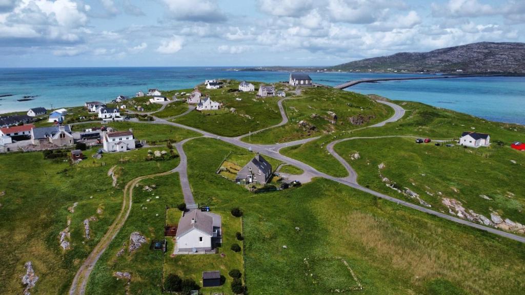 a small village on a hill with the ocean at Sealladh A’ Chaolais (Eriskay) in Eriskay
