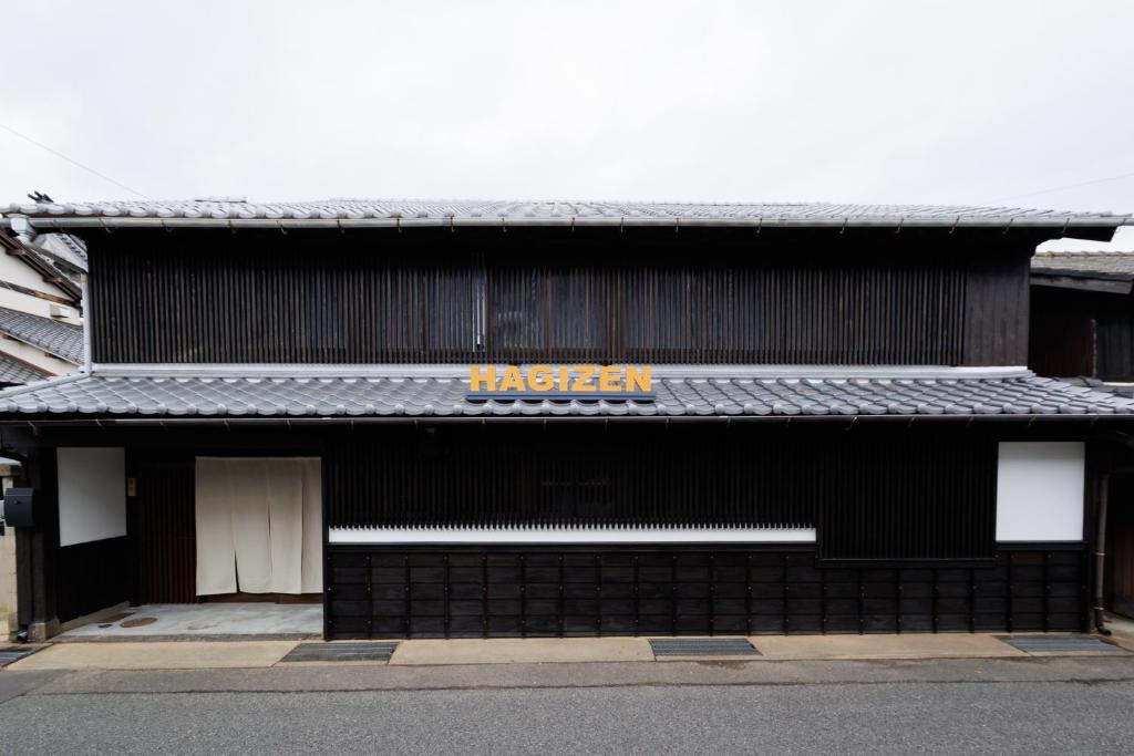 a black building with a sign on the side of it at Hagizen in Hagi