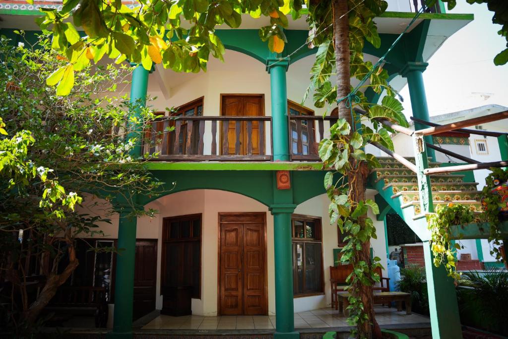 a green and white building with a balcony at Bungalows Puerta de Sol in Brisas de Zicatela