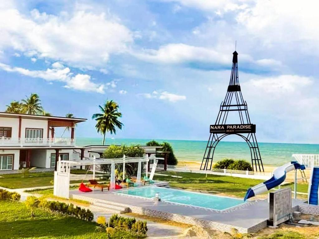 a house with a swimming pool and a water slide at Nara Paradise Beach in Narathiwat