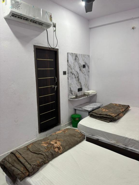 a room with two beds and a black door at Dixit's Residency in Godarpura