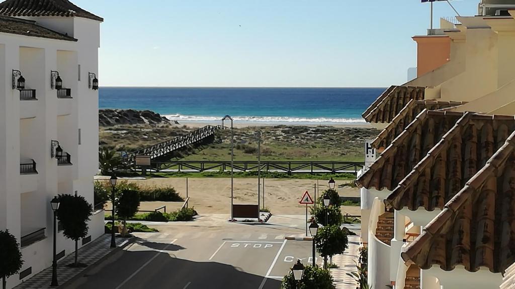 uma vista para a praia entre dois edifícios em Apartamentos y Áticos Zahara em Zahara de los Atunes