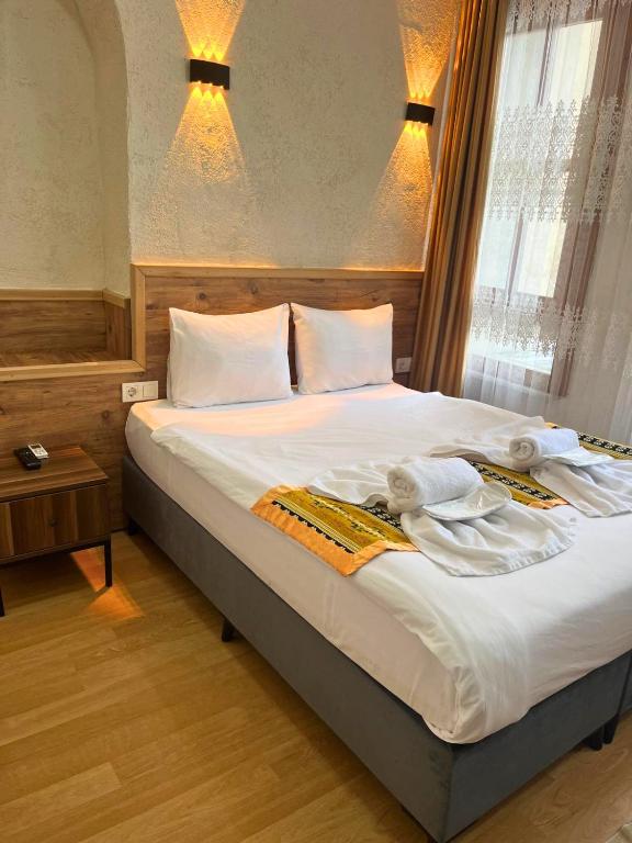 a bedroom with a large bed with towels on it at Otantik Hotel in Istanbul