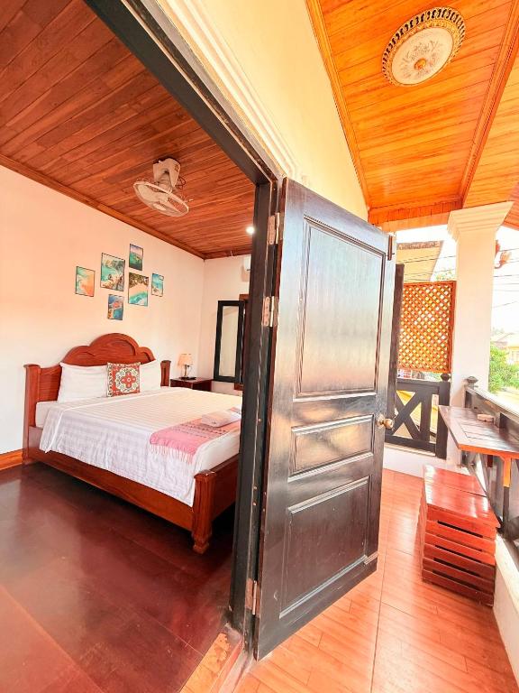a bedroom with a bed and a wooden ceiling at Elephant Hotel Luang Parabang in Luang Prabang