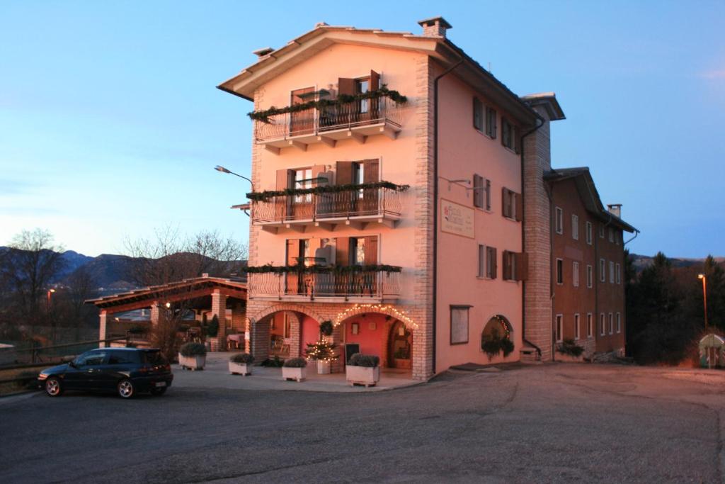 a building with a car parked in front of it at Hotel Piccola Mantova in Bosco Chiesanuova