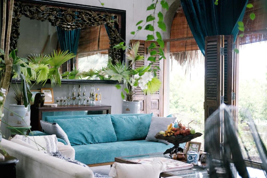 a living room with a blue couch and some plants at Neverland de Papillons in Sa Ðéc