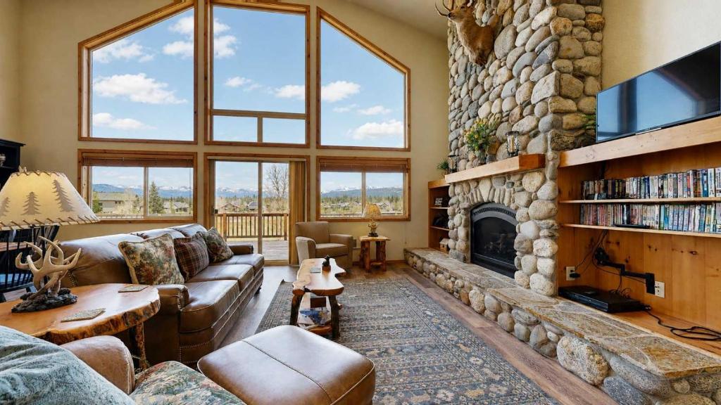 a living room with a large stone fireplace at Spacious McCall Home Near Golf Course in McCall