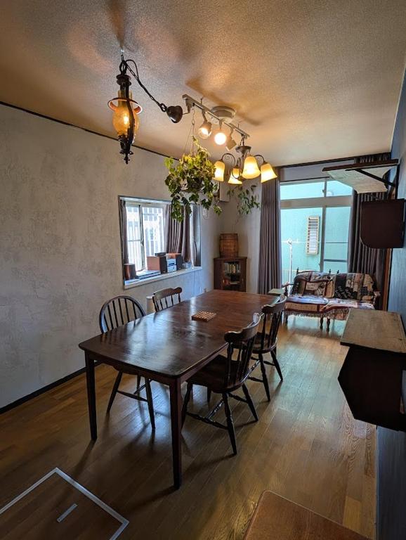 a living room with a wooden table and chairs at アトイエ-Atoie- in Odawara