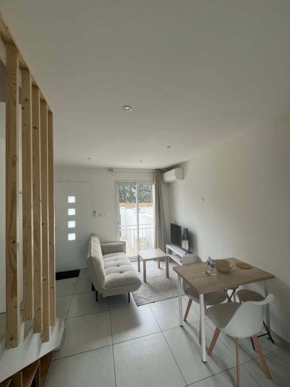 a living room with a table and a chair at Maison mitoyenne in Gignac-la-Nerthe