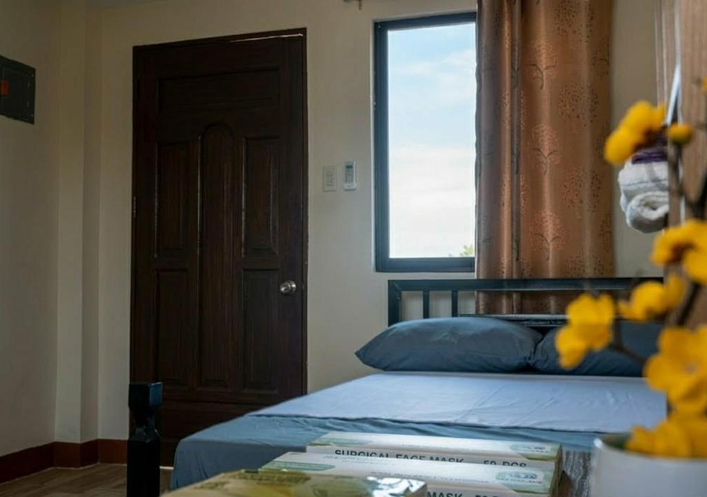 a bedroom with a bed with a window and a table at Negradas Transient Inn-with Air-conditioning in Manolo Fortich