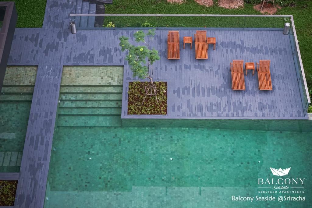 an overhead view of a swimming pool with orange chairs at Balcony Seaside Sriracha Hotel & Serviced Apartments in Si Racha