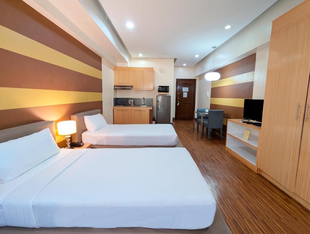 a hotel room with two beds and a kitchen at Prince Plaza II Condotel in Manila
