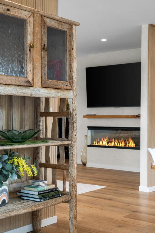 a living room with a fireplace and a tv at Mellow mountains, boutique beach house in Portarlington