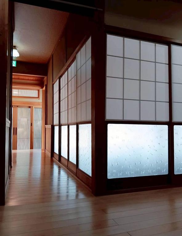 an empty room with large windows and wooden floors at やぎみちの家 yagimichi-noie in Sasebo