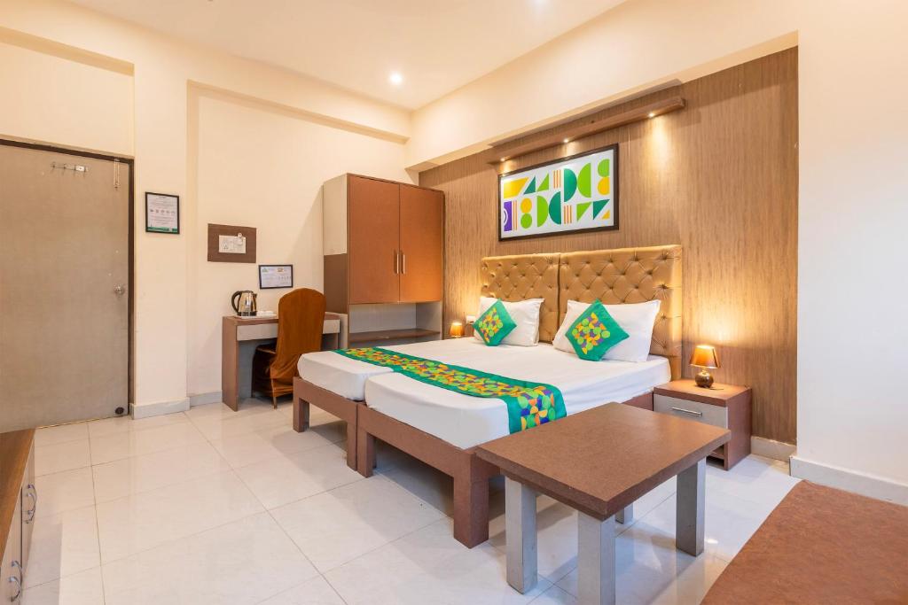 a hotel room with a bed and a table and a desk at Treebo Maple Delite in Lucknow