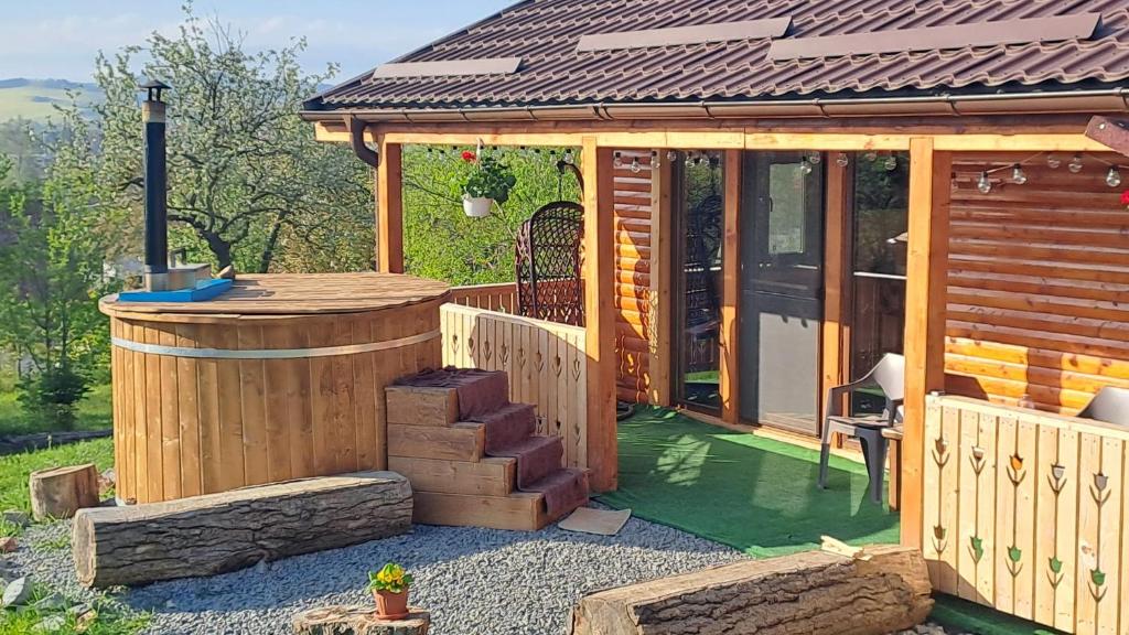 a large wooden cabin with a gazebo at Cabana Laura in Tîrnăveni